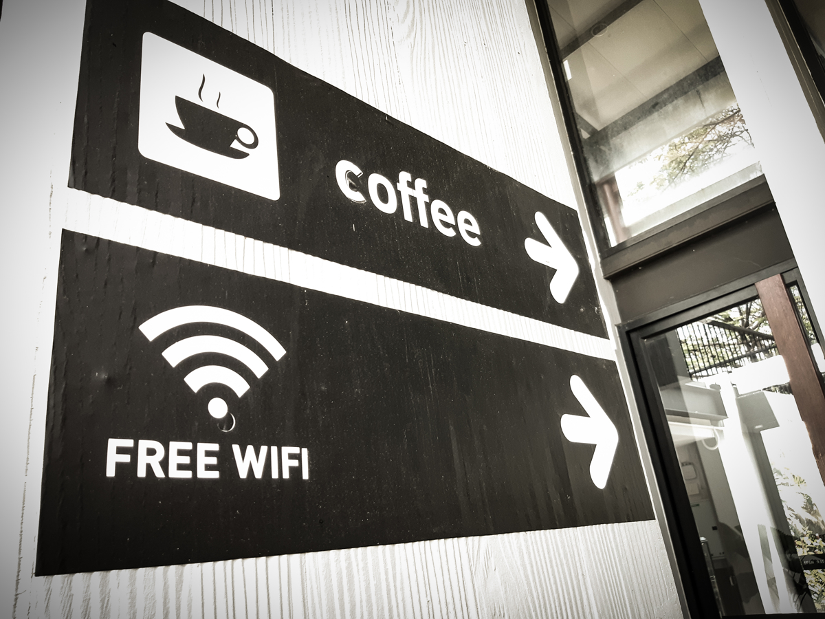 Signs pointing to a coffee shop with free Wi-Fi.